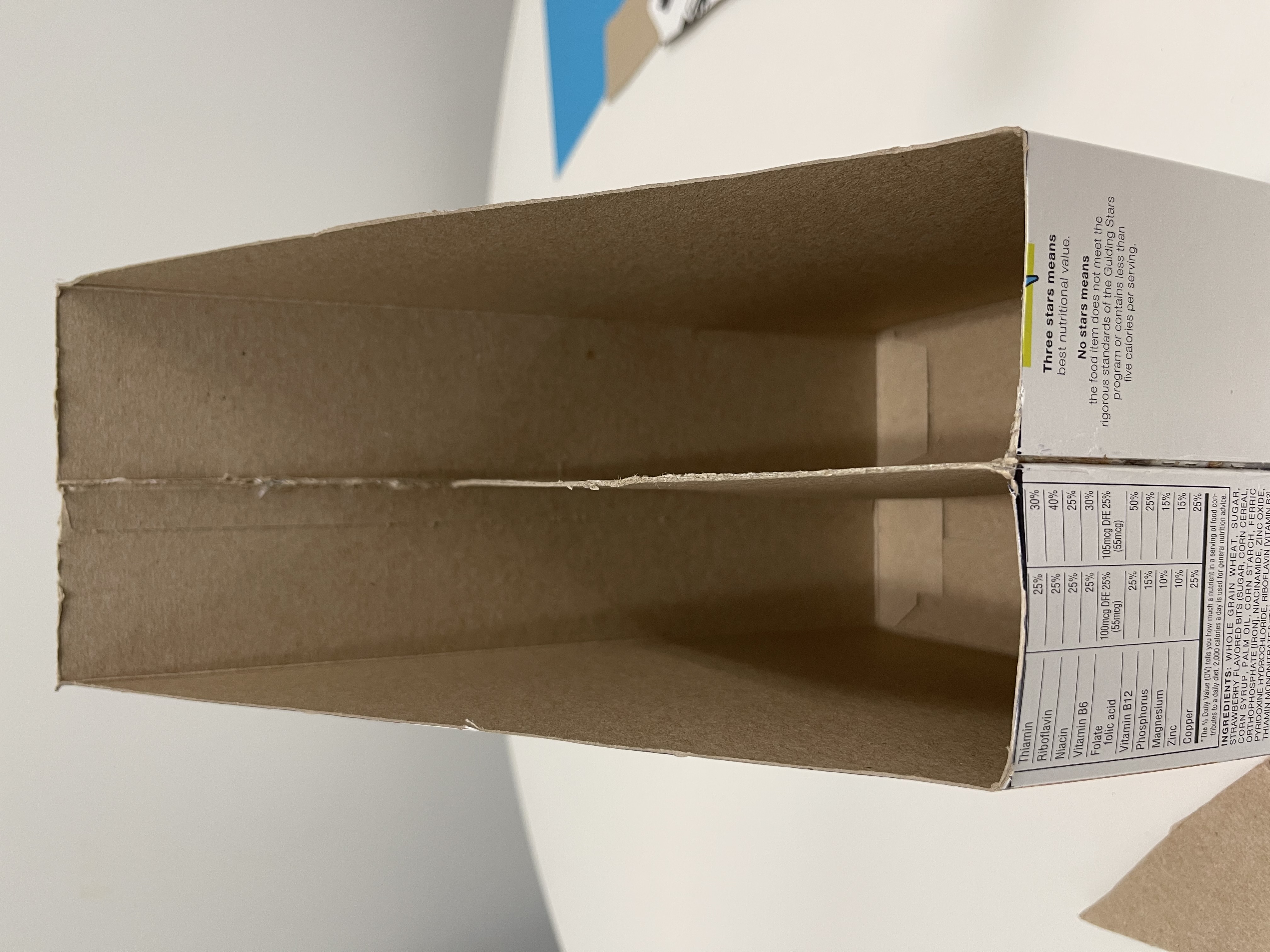 two cut cereal boxes with cardboard showing