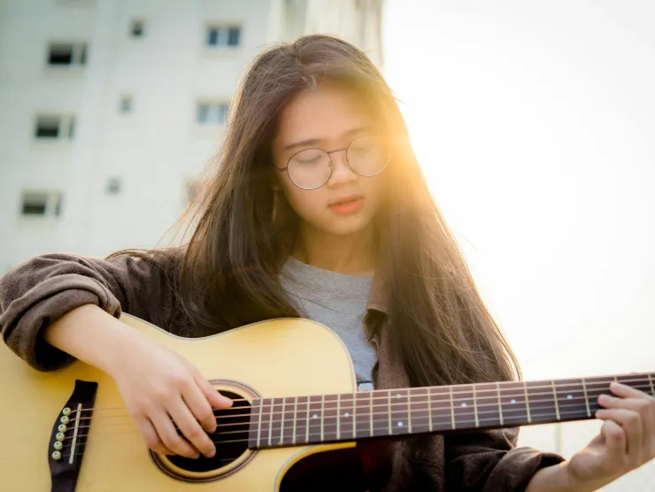 Teen playing acoustic guitar