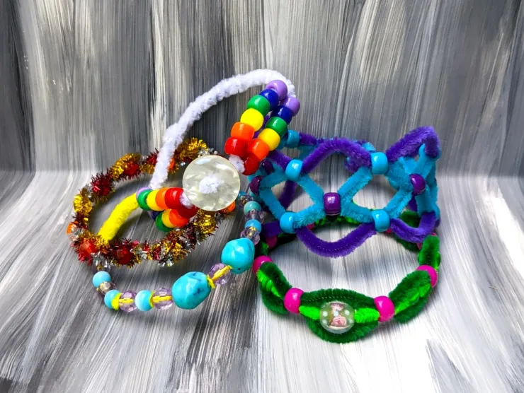 A pile of colorful bracelets made from craft beads and chenille sticks
